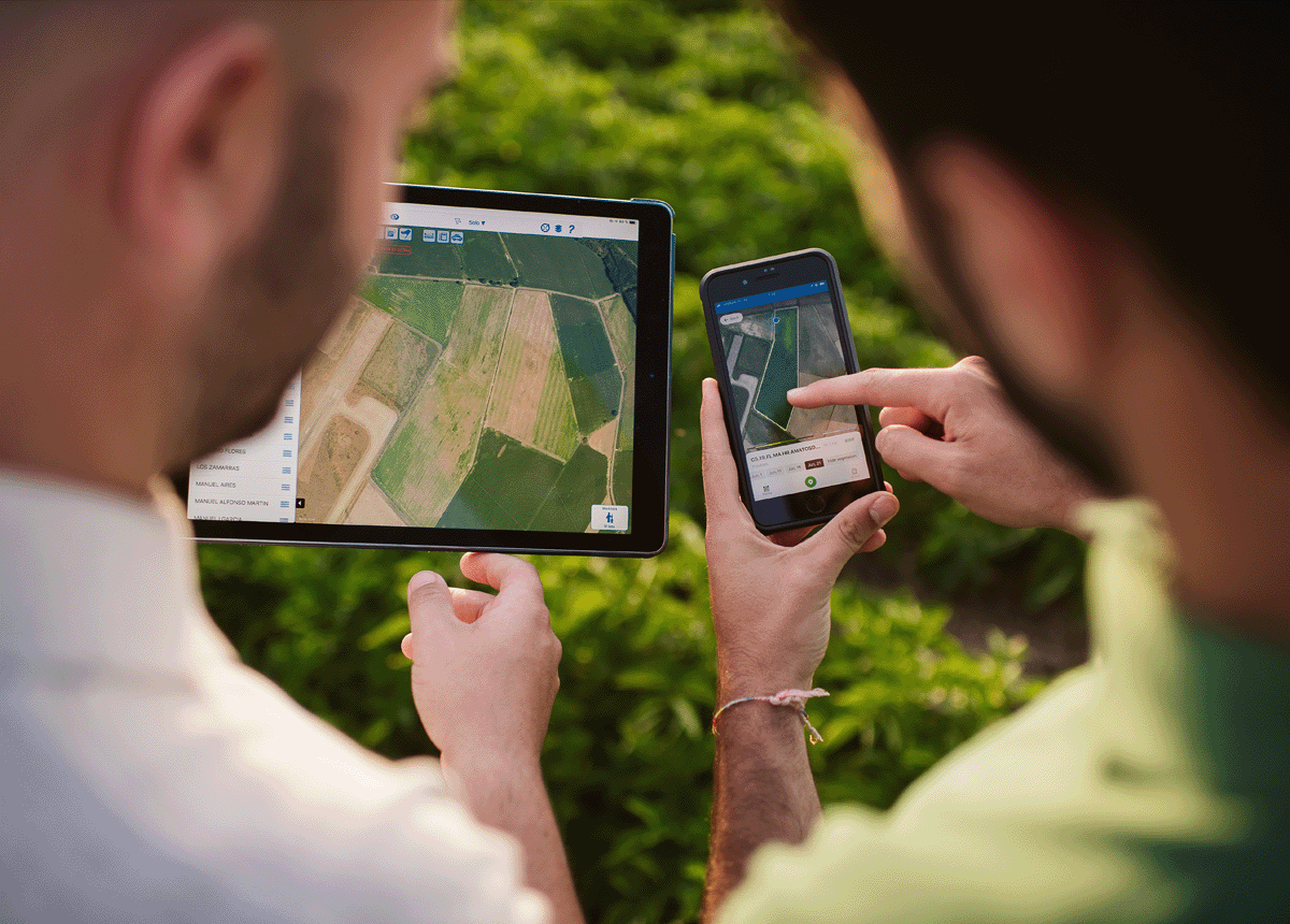 Two people looking at aerial views of land on their mobile devices